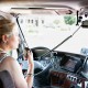 Woman truck driver in a big rig talking on the C.B. radio.